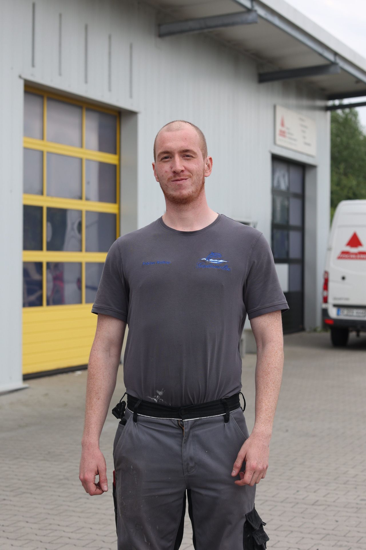 Ein Mann steht vor einem Gebäude mit einem gelben Garagentor.