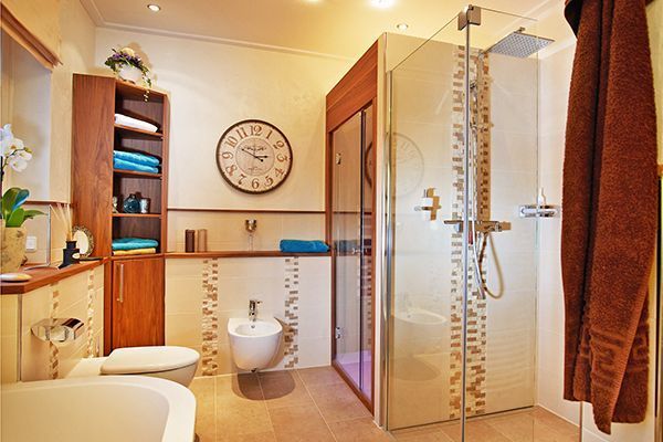 Ein Badezimmer mit einer Uhr an der Wand über der Toilette