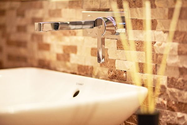 Ein Waschbecken im Badezimmer mit einem Wasserhahn an der Wand.