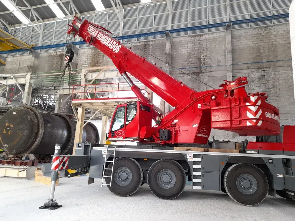 Una gran grúa roja está estacionada en un almacén.
