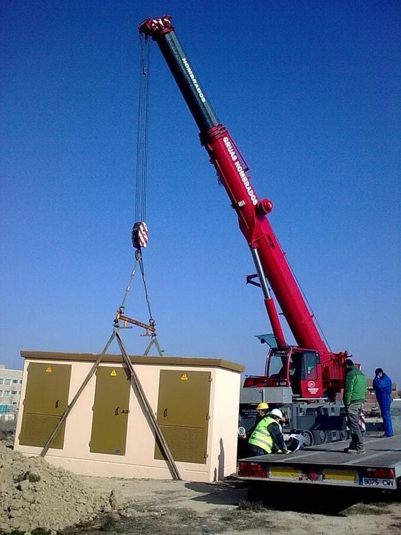 Una grúa roja está levantando un edificio en el aire