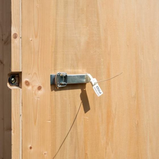 Des caisses de stockage en bois empilées dans une allée d'entrepôt sur un sol en béton