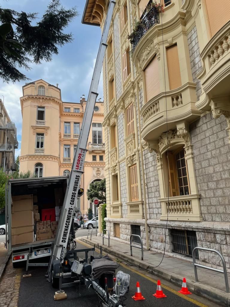 Un camion nacelle blanc avec l'inscription rouge « LEGROS »