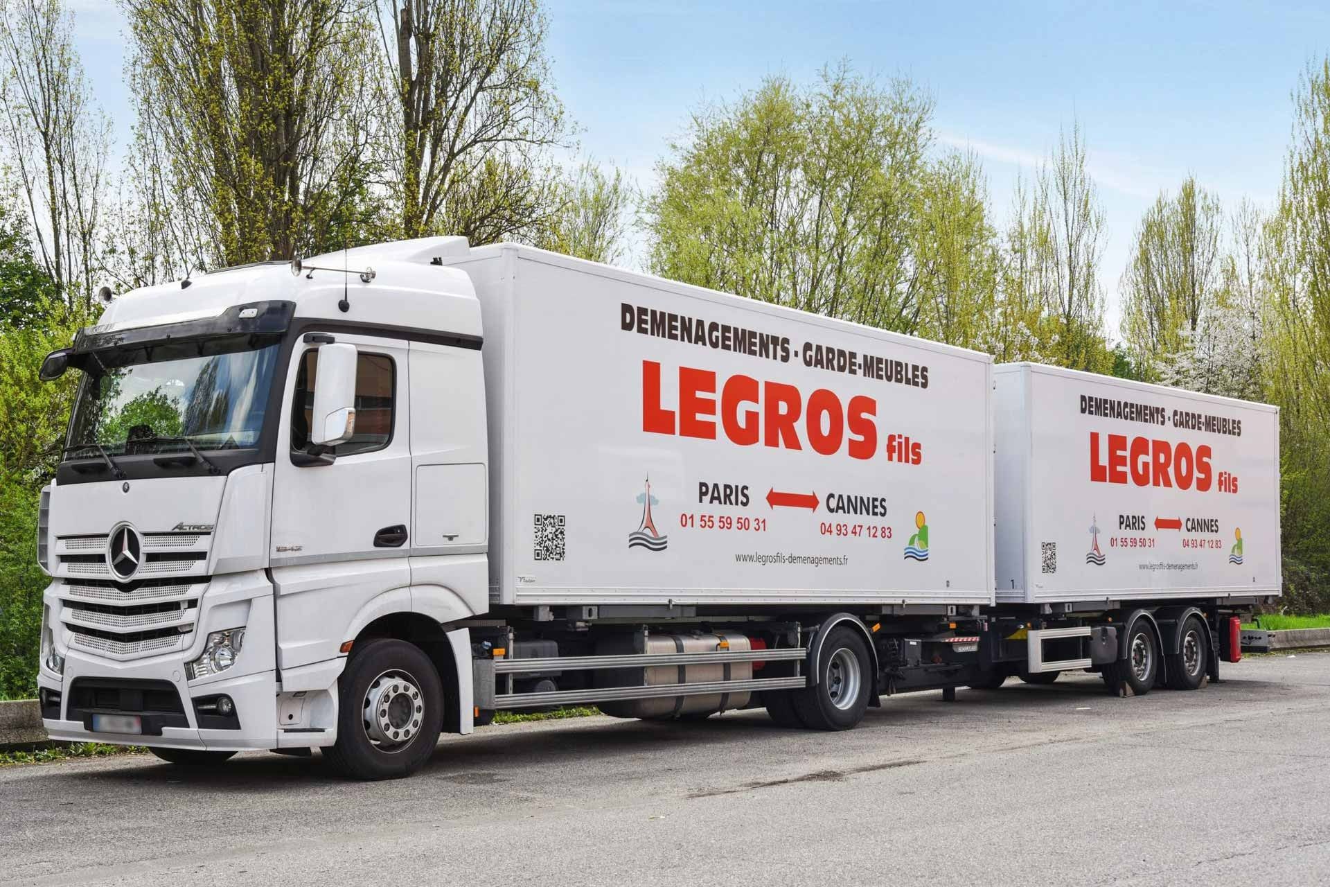 Un semi-remorque Déménagement Legros Fils est stationné en bord de route.