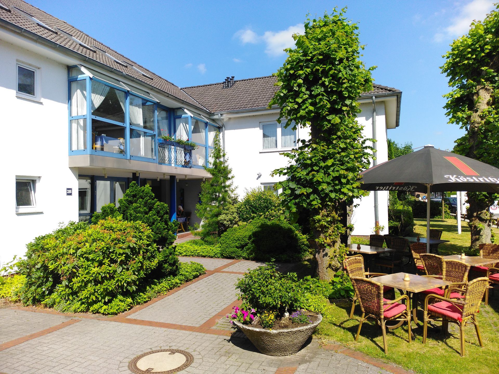 Ein großes weißes Gebäude mit einem schwarzen Regenschirm davor