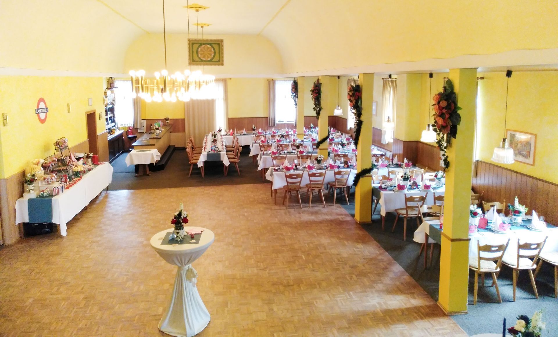 Ein großer Raum mit Tischen und Stühlen und einem kleinen Tisch in der Mitte