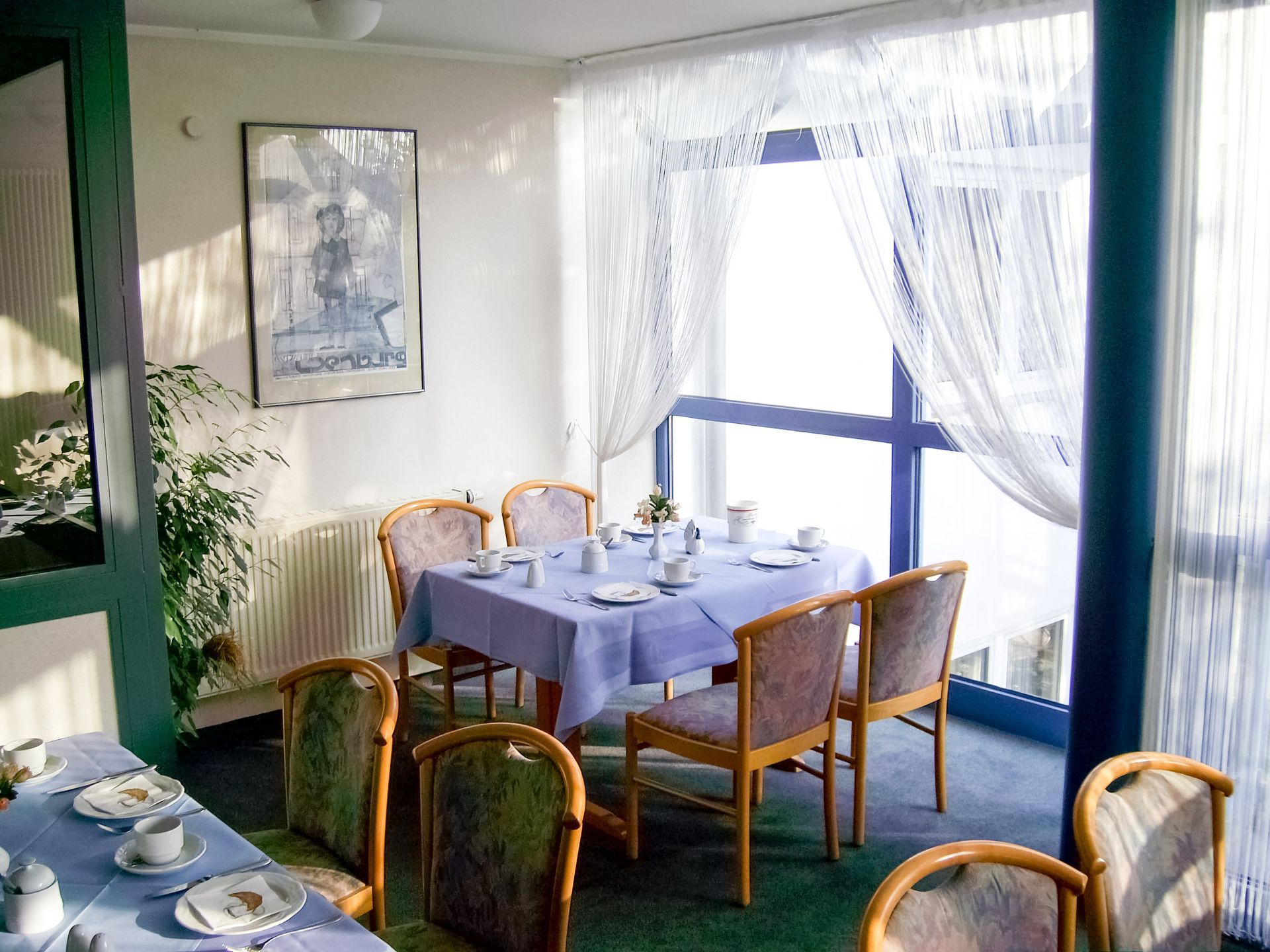 Ein Esszimmer mit Tischen und Stühlen und einem großen Fenster