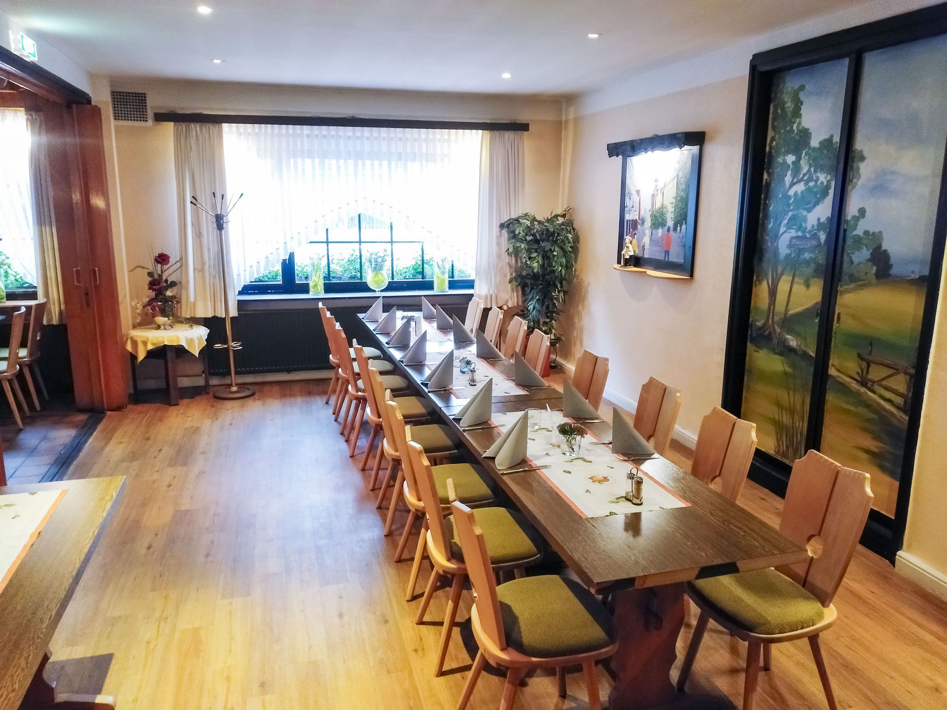 Ein langer Tisch und Stühle in einem Raum mit einem Fenster