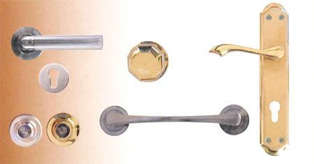 Un montón de diferentes tipos de manijas de puerta sobre una mesa.