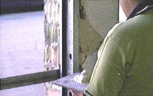 Un hombre está trabajando en una puerta con una espátula.