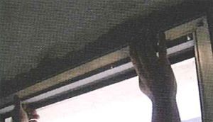 Una persona está colgando una cortina del techo.