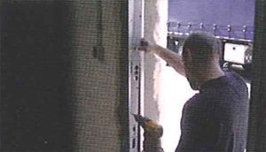 Un hombre está trabajando en una puerta en una habitación oscura.