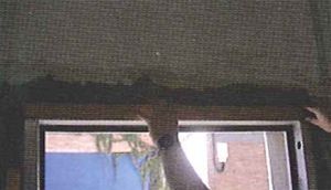 Una persona está limpiando una ventana con una aspiradora.