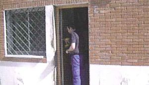 Un hombre está parado en la puerta de un edificio de ladrillo.