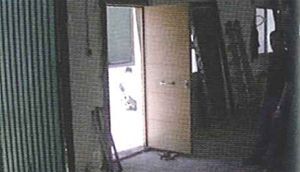 Una fotografía en blanco y negro de una habitación con una puerta abierta.