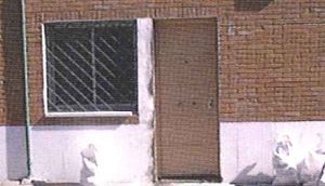 Un edificio de ladrillo con una ventana y una puerta.