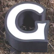 Una letra g en blanco y negro está sobre una superficie de mármol.