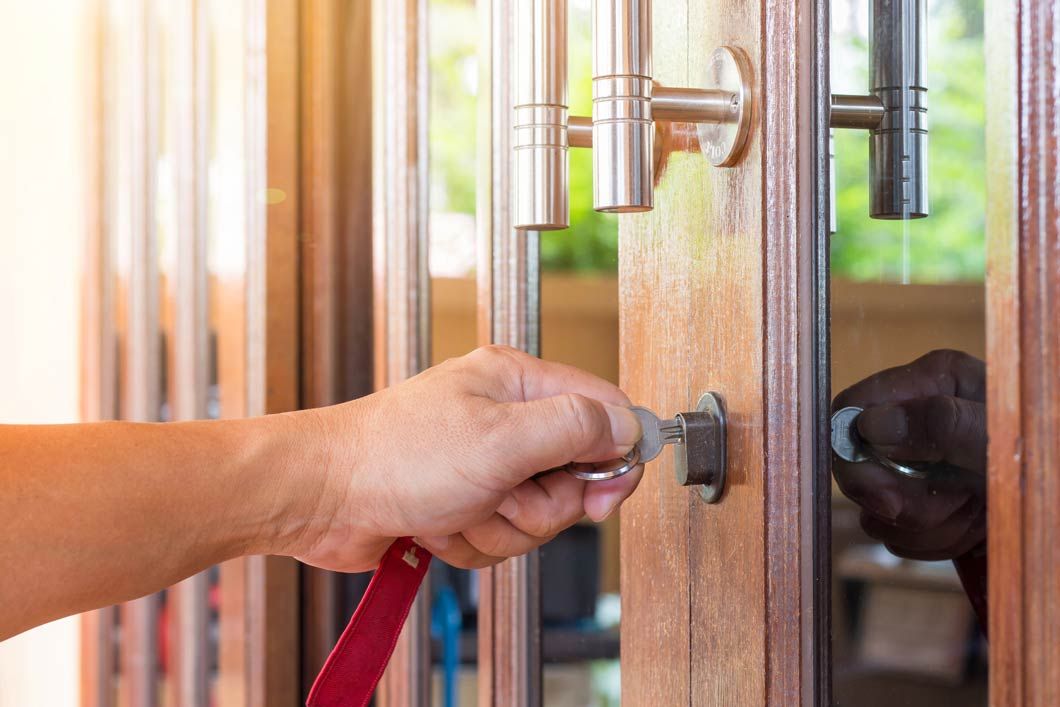 Una persona está usando una llave inglesa para abrir una puerta de madera.