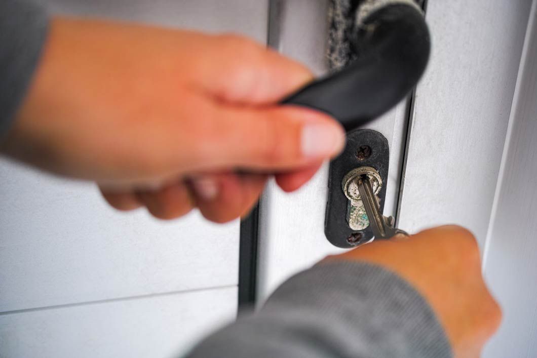 Una persona está abriendo una puerta con una llave.