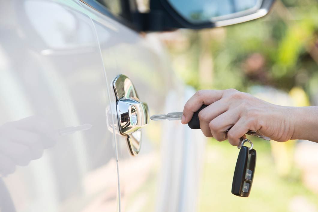 Una persona está abriendo la puerta de un coche con una llave.