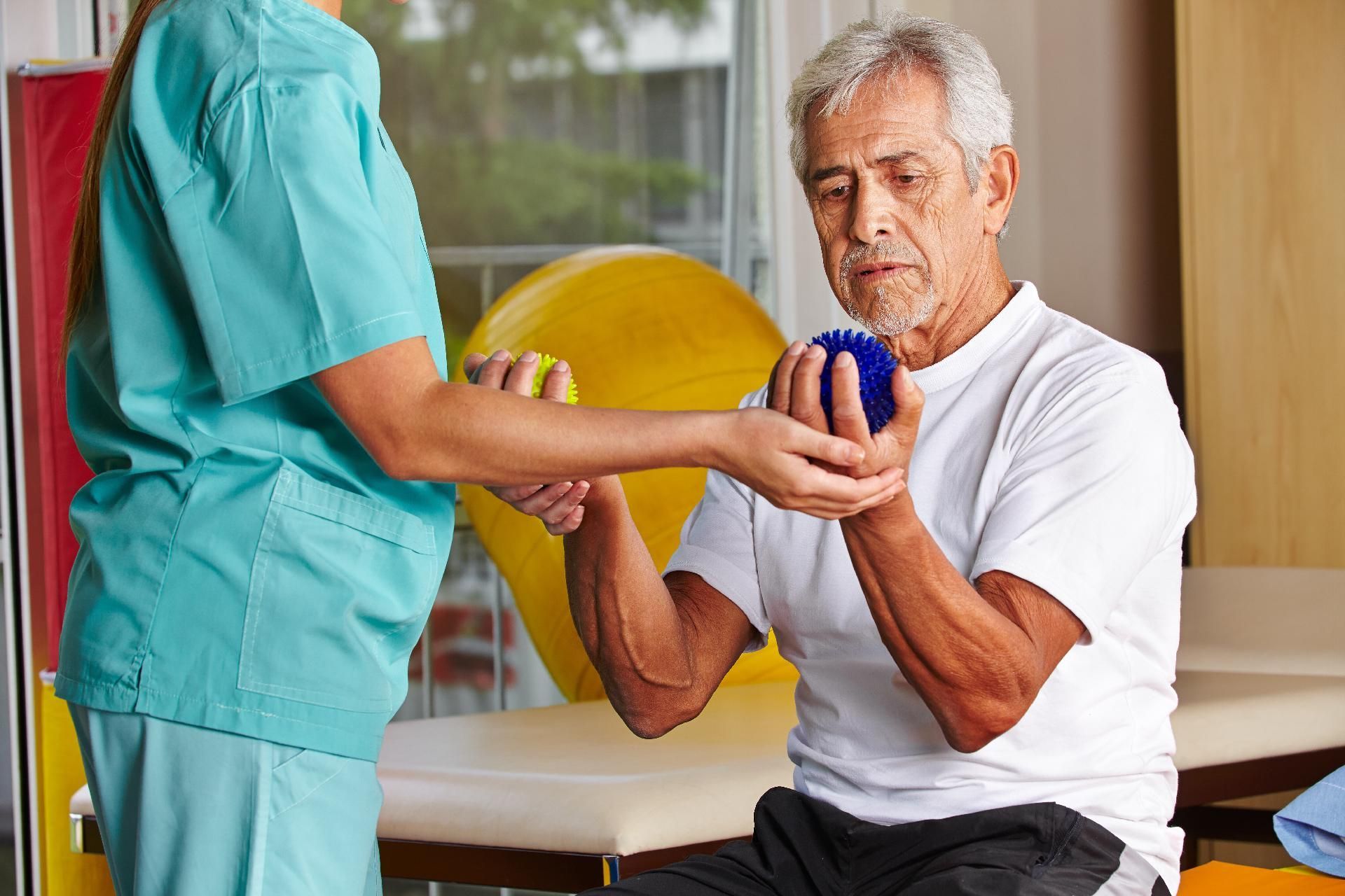 Therapeut hilft Patient beim Training Therapeut hilft Patient beim Training mit einer blauen Hantel in einer Klinikumgebung