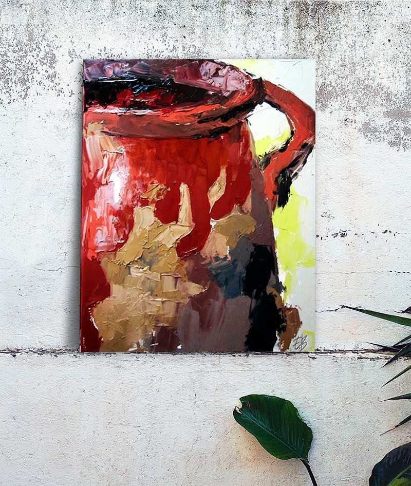 Jarra pintada de rojo sobre una pared blanca texturizada, con una planta verde en la esquina inferior derecha.