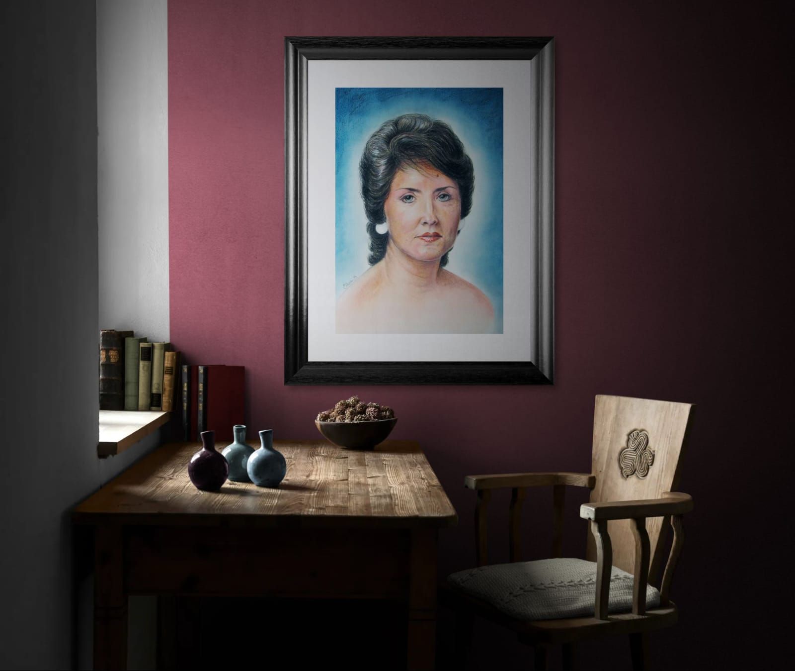 Un retrato enmarcado de una mujer cuelga sobre una mesa de madera.