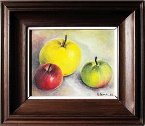 Un cuadro de tres manzanas en un marco de madera.