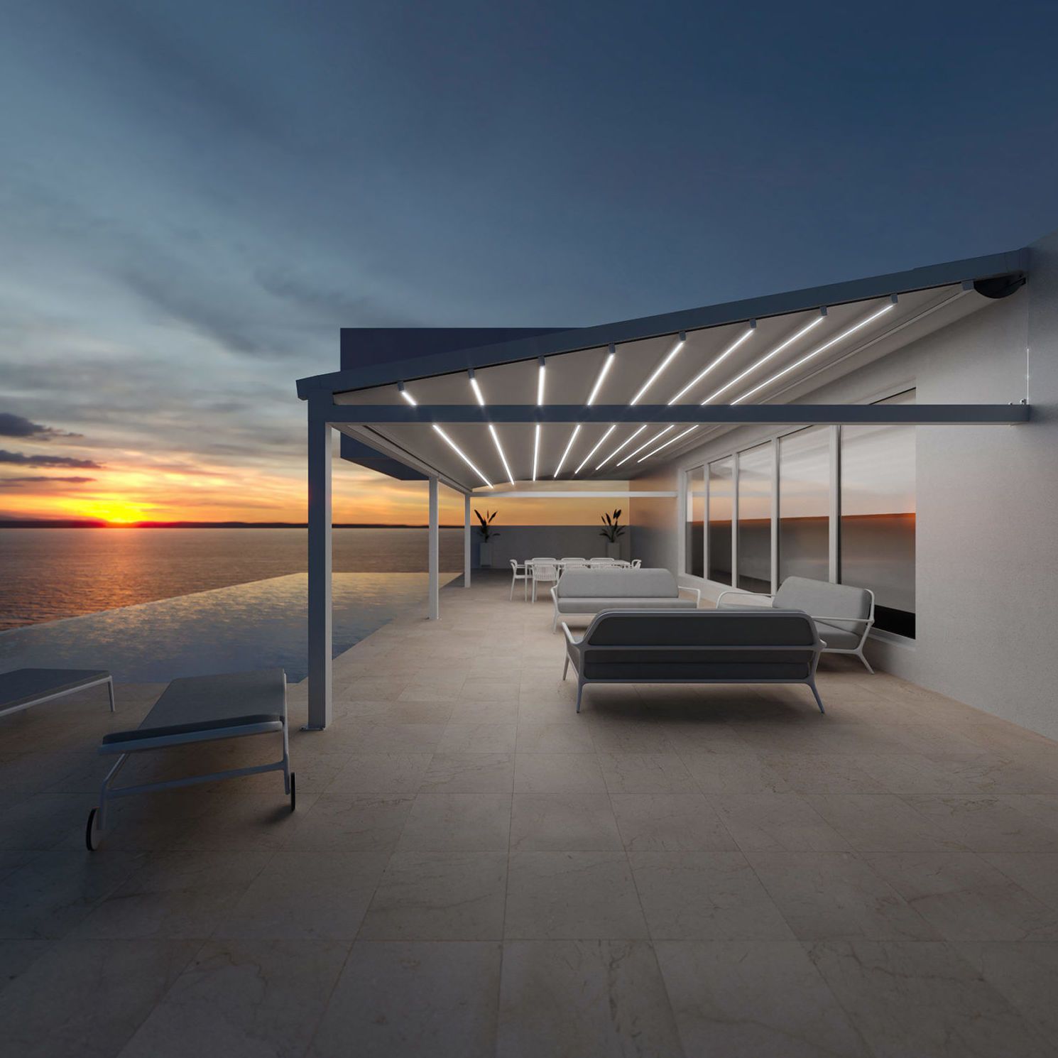 Patio con vista al agua al atardecer, con modernos muebles grises bajo una pérgola con luces.