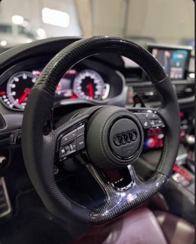 Volante de fibra de carbono de un Audi, con detalles en rojo en el tablero.