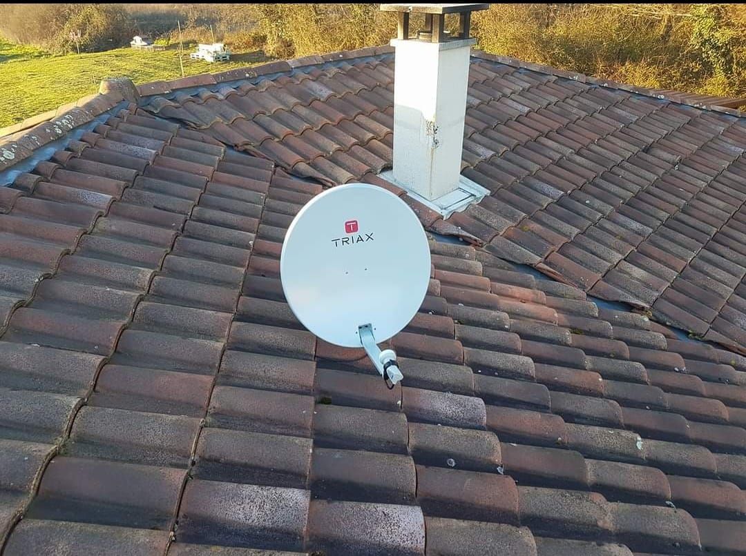 Une parabole blanche sur des tuiles