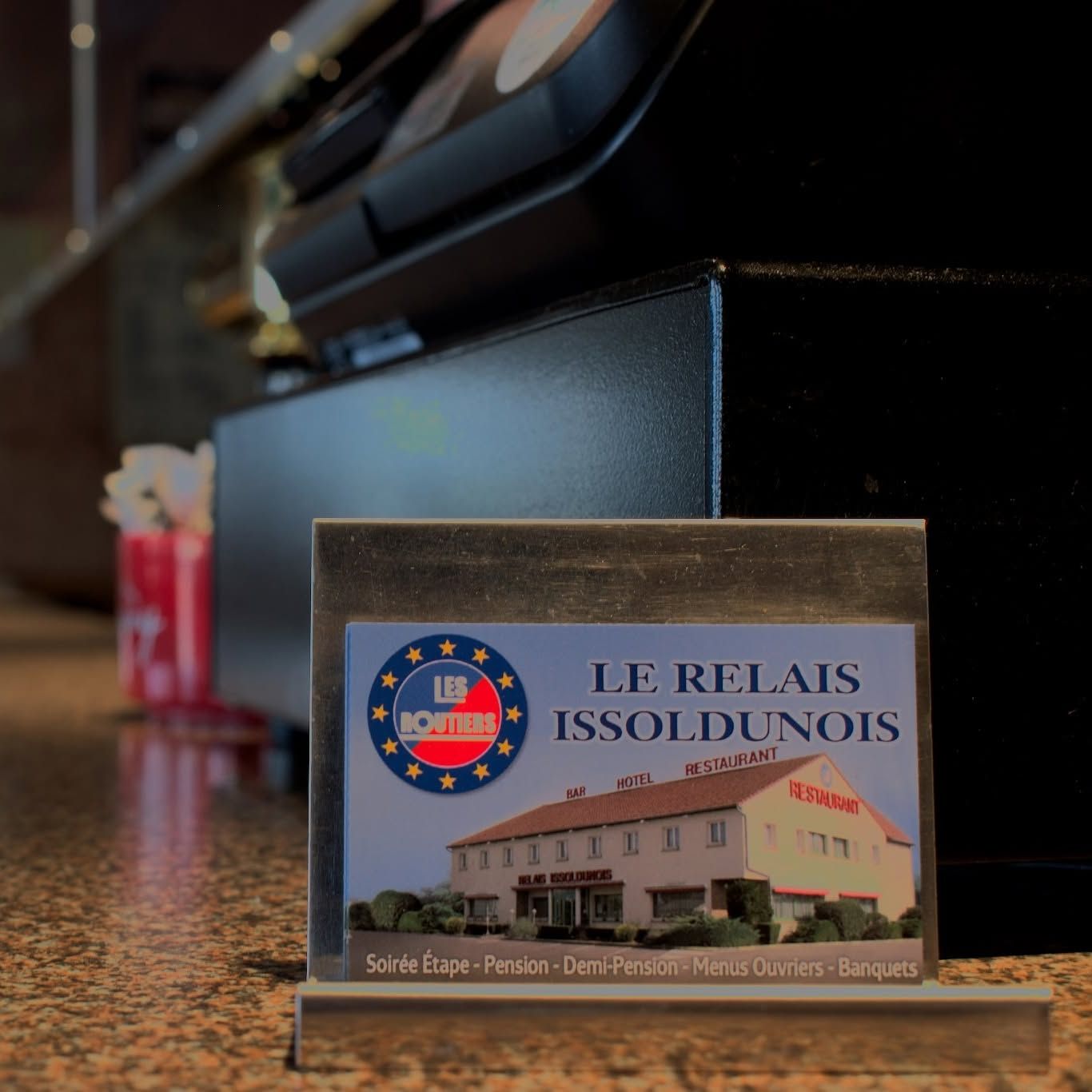 Carte de visite du RELAIS ISSOLDUNOIS sur un comptoir.