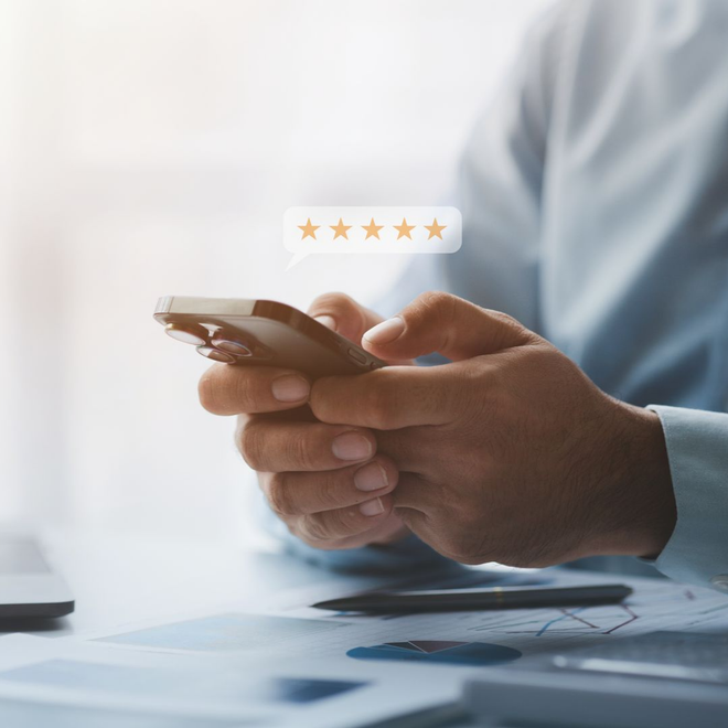 Une personne utilise un smartphone avec une superposition d'évaluation à 5 étoiles.