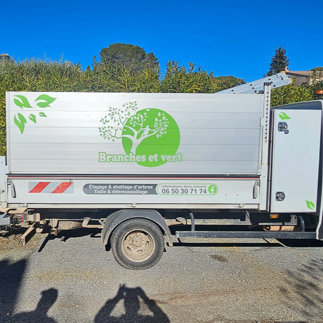 Camion argenté avec le logo Branches et vert, stationné à l'extérieur.