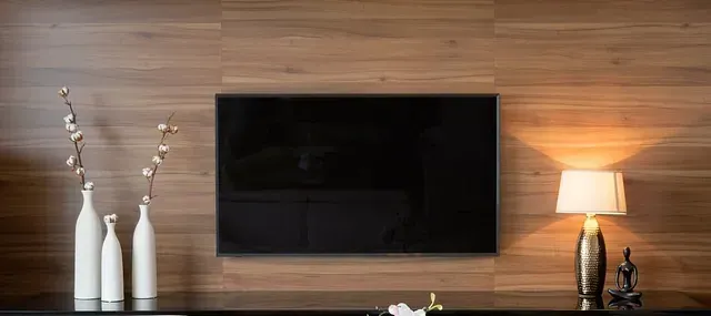 Una sala de estar con televisor de pantalla plana y una lámpara.