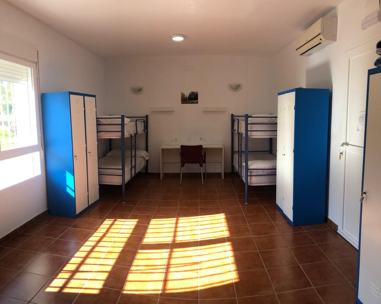 Una habitación con literas y un escritorio.