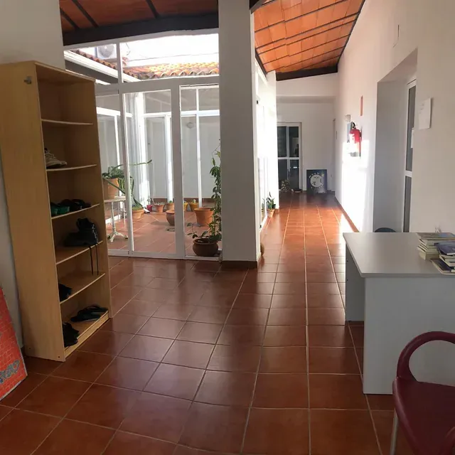 Un largo pasillo con un escritorio y un estante.