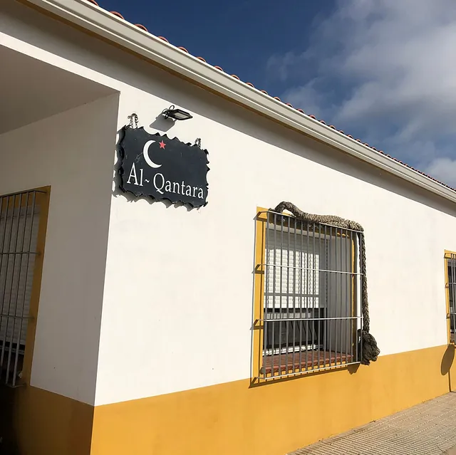 Un edificio blanco con un cartel que dice al-qantara