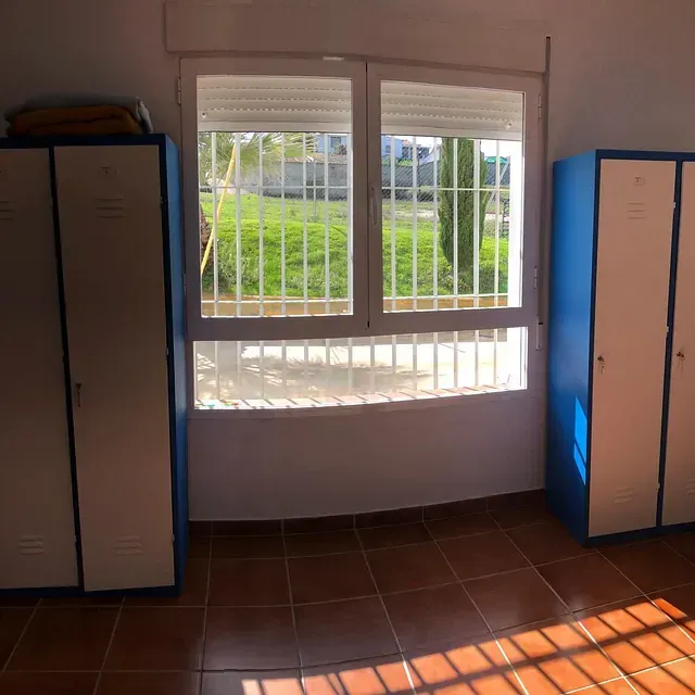 Una habitación con armarios azules y una ventana grande.
