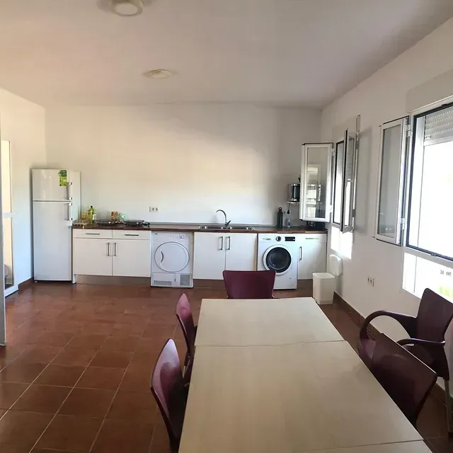 Una cocina con mesa y sillas y lavadora y secadora.