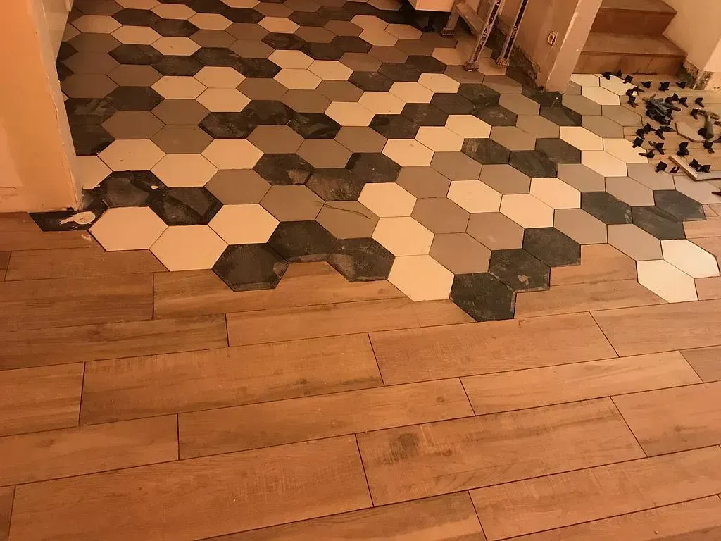 Carrelage posé à côté d'un parquet découpé