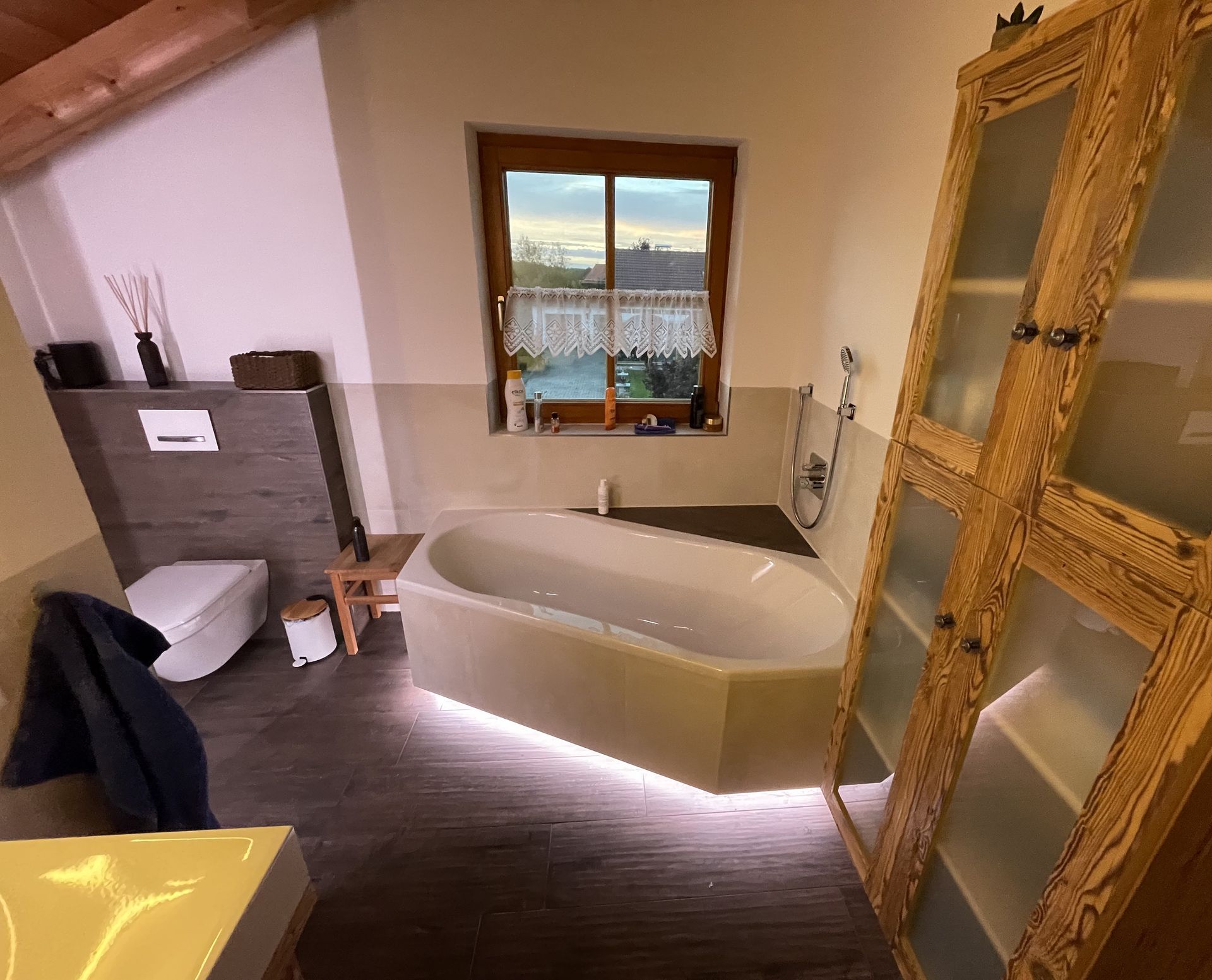 Ein Badezimmer mit einer beleuchteten Eckbadewanne