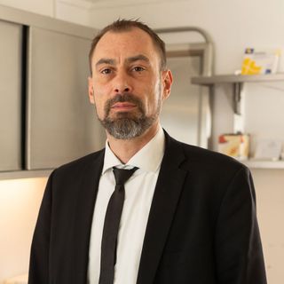 Ein Mann in Anzug und Krawatte steht in einer Küche