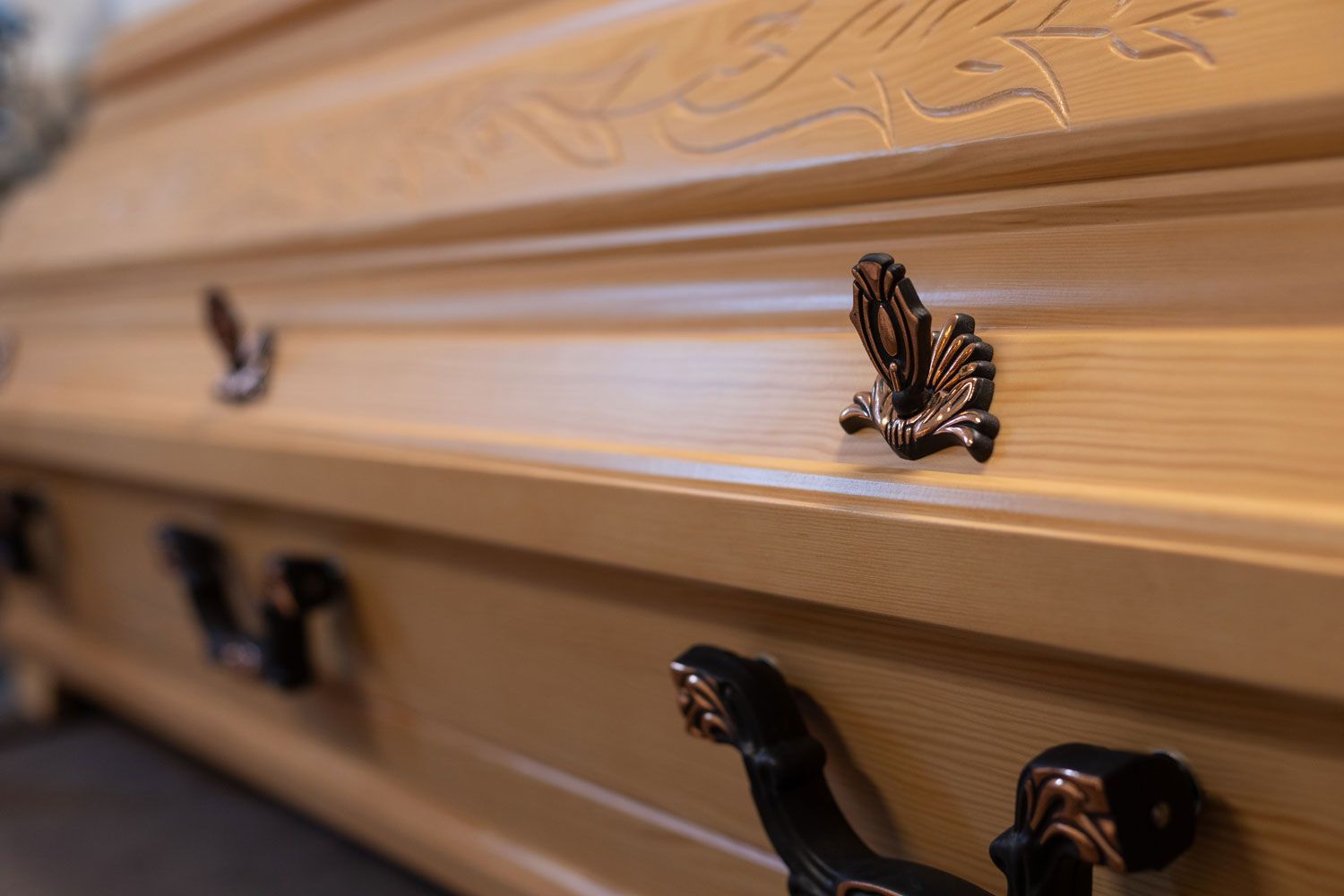 Eine Nahaufnahme eines Holzsarges mit einem Schmetterling darauf.