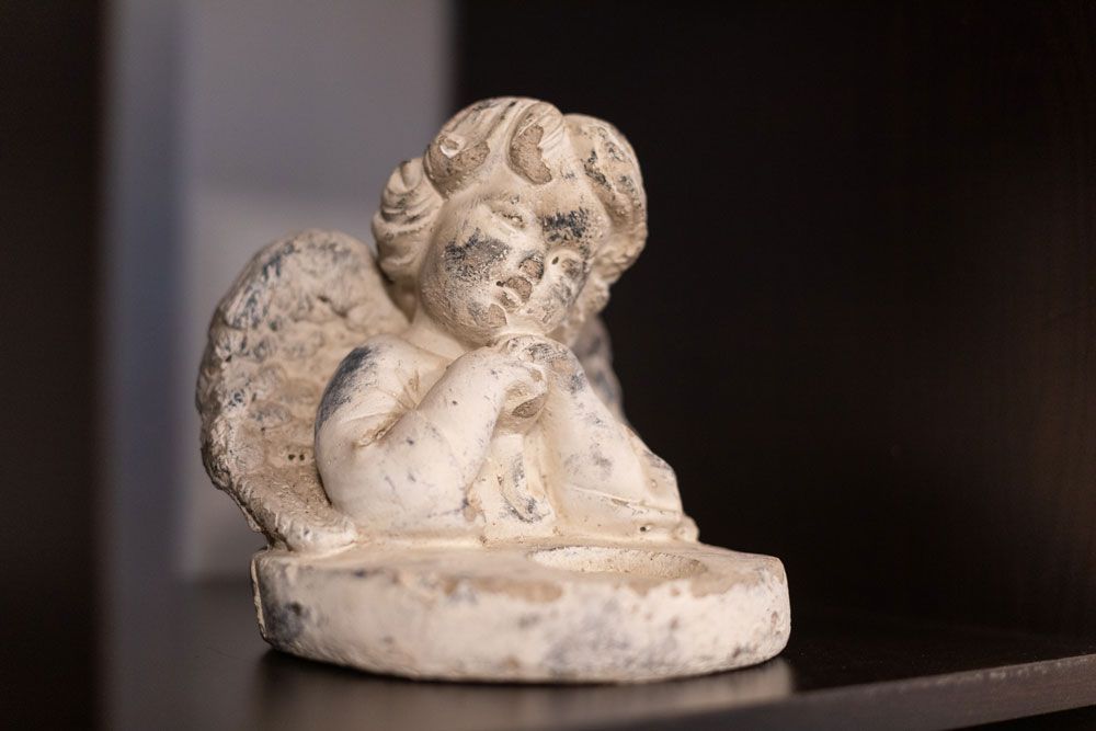 Eine Engelsstatue steht auf einem Regal.