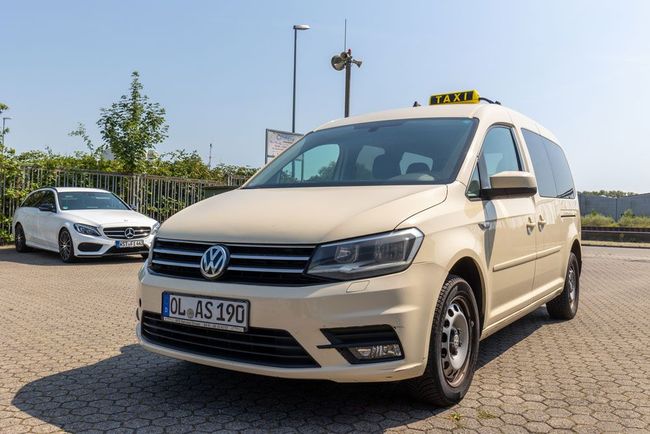 Ein schwarzer Mercedes Benz parkt vor einem Gebäude.