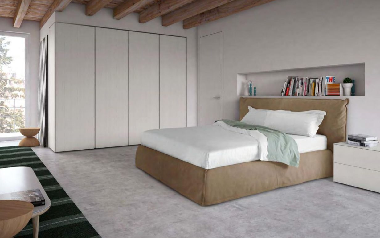 Un coin chambre avec une tête de lit style oreiller en velours beige