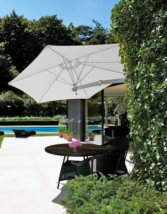 Un parasol mural dans un jardin végétalisé avec piscine
