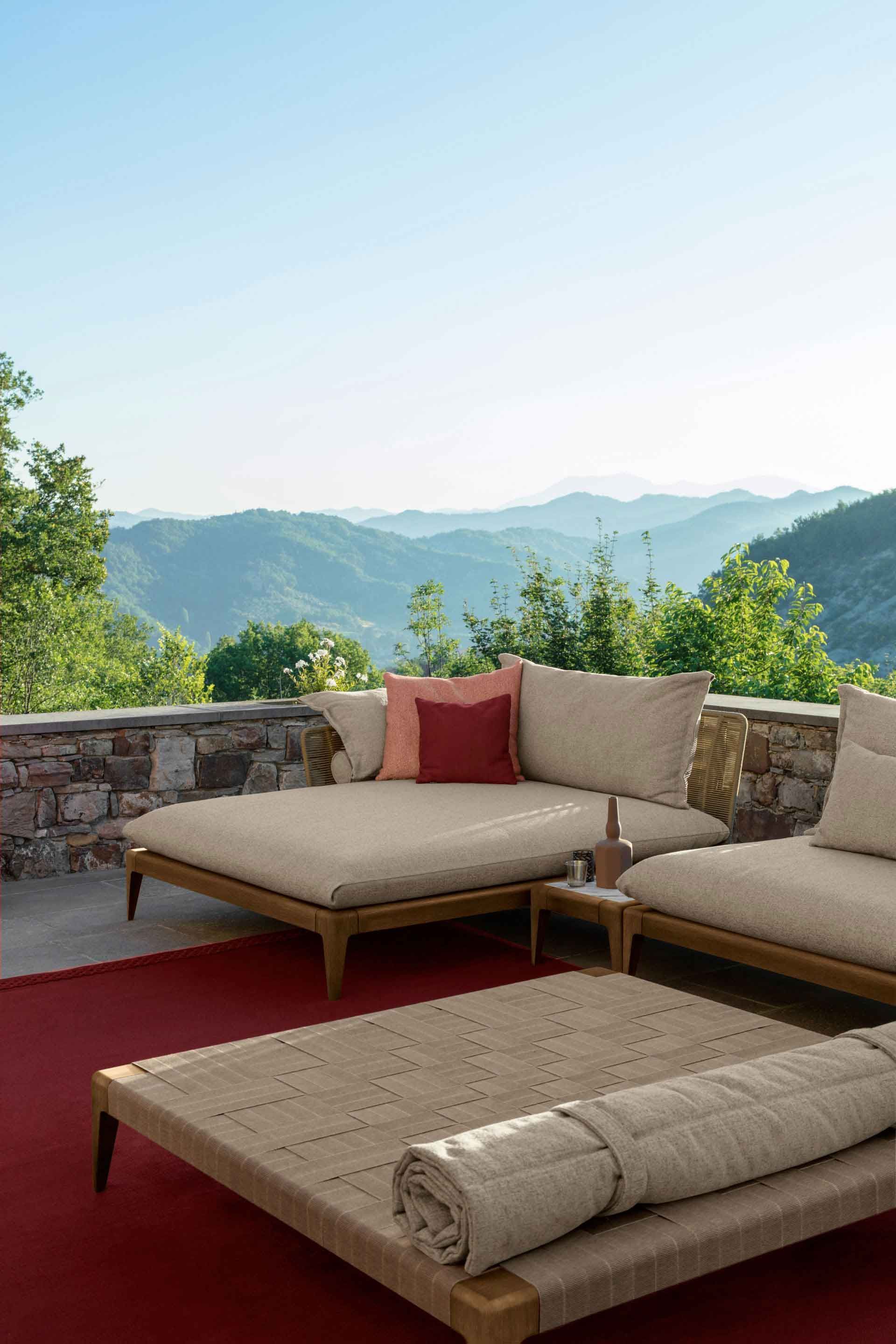 Coin salon en teck et tissu sur une terrasse avec vue sur les montagnes