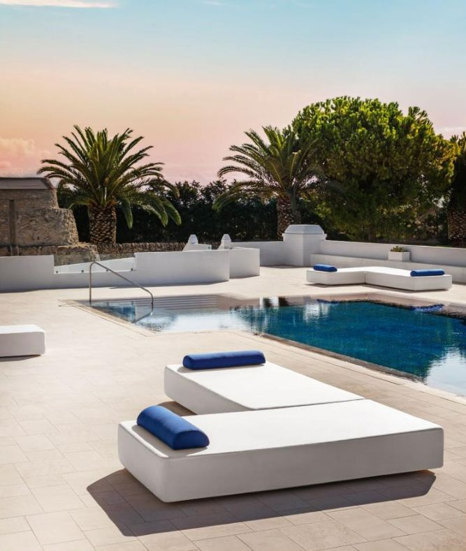 Transats au design minimaliste bleu et blanc autour d'une piscine